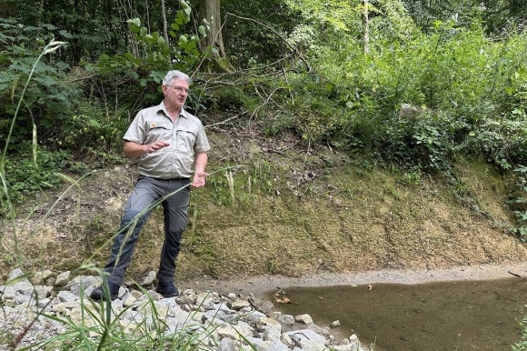 Andreas Kiesinger steht im Wald und erklärt die Funktionsweise der Rigolen. 