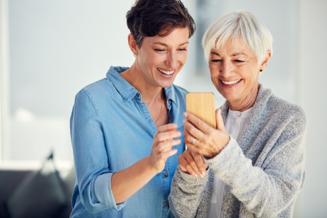 Zwei Frauen schauen gemeinsam in ein Smartphone. 