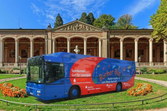 Fotomontage: Bücherbus steht auf einer Grünfläche vor der Trinkhalle Baden-Baden.